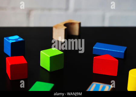 Colorful wooden figures on a black table. Stock Photo