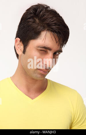 Young man winking towards camera Stock Photo