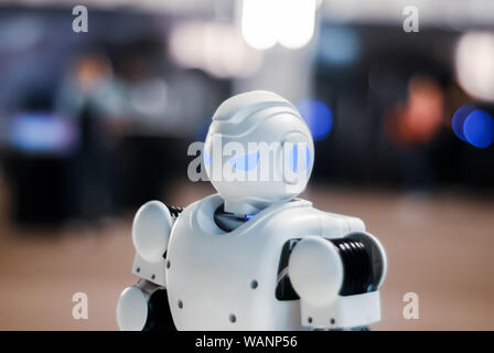 head of toy robot with glowing blue eyes on a blurred background Stock Photo