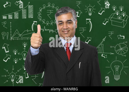 Businessman with business plan drawing and showing thumbs up sign Stock Photo