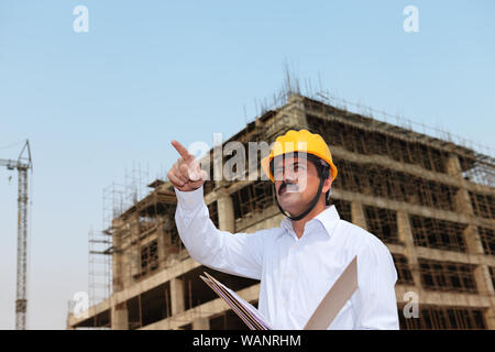 Architect holding paperwork at construction site Stock Photo