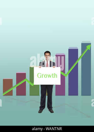 Businessman showing placard growth written on it and in front of bar graph rising upward Stock Photo