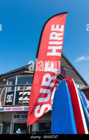 A brightly coloured banner advertising the Surf Hire equipment in Newquay in Cornwall. Stock Photo