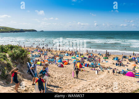 Holidaymakers on a staycation holiday enjoying themselves on a sunny Fistral Beach in Newquay in Cornwall. Stock Photo