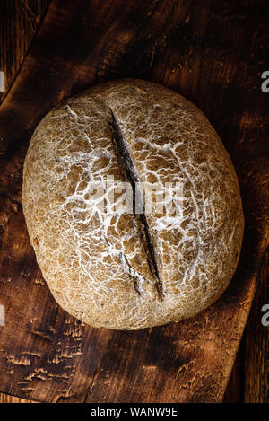 Freshly baked loaf of rye bread on cutting board. View from above Stock Photo