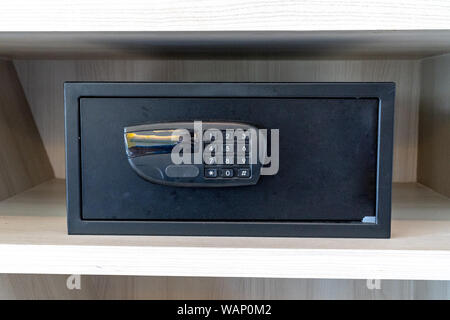 black safe box, stroungbox in the wood pattern shelf in resort bedroom. Stock Photo