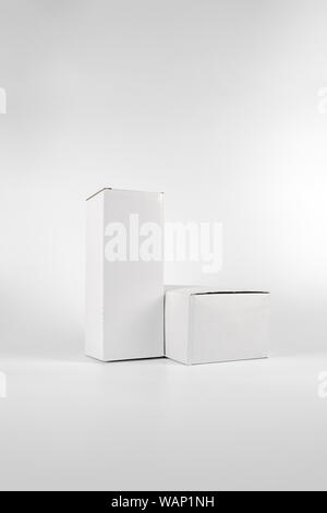 White two paper boxes - tall and fat lay on the white background in studio shot with clipping paht. Stock Photo