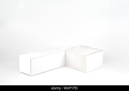 White two paper boxes - tall and fat lay on the white background in studio shot with clipping paht. Stock Photo
