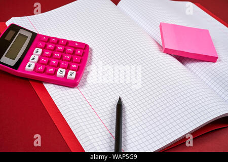 open notebook with checkered pages and calculator and pencil Stock Photo