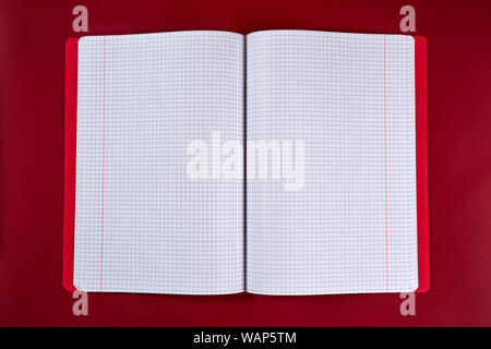 open notebook with checkered pages on a red background Stock Photo