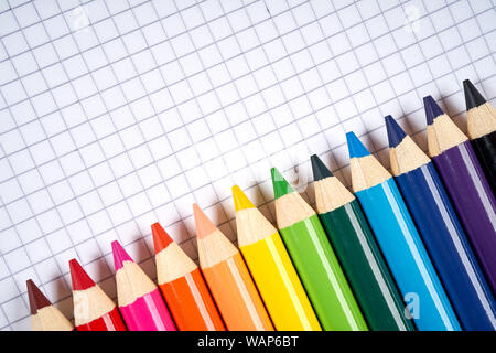 colored pencil crayons on an open checkered notebook Stock Photo