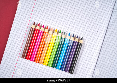 colored pencil crayons on an open checkered notebook Stock Photo