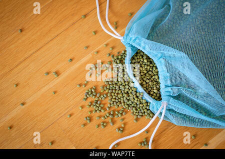 Top view of green mung bean in blue reusable package on wooden background. Healthy eating concept Stock Photo