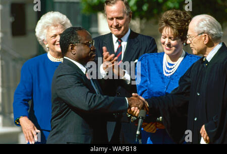 Washington DC. USA, October 18, 1991 Judge Clarence Thomas is sworn as Associate Justice of the United States Supreme Court by Justice Bryon White on the White House South Lawn as his wife Virginia Thomas holds the Bible and United States President H.W. Bush and First Lady Barbara Bush look on. Stock Photo