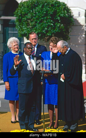 Washington DC. USA, October 18, 1991 Judge Clarence Thomas is sworn as Associate Justice of the United States Supreme Court by Justice Bryon White on the White House South Lawn as his wife Virginia Thomas holds the Bible and United States President H.W. Bush and First Lady Barbara Bush look on. Stock Photo