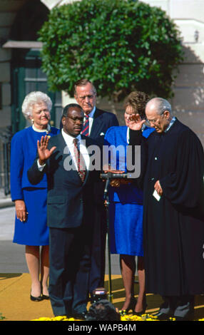 Washington DC. USA, October 18, 1991 Judge Clarence Thomas is sworn as Associate Justice of the United States Supreme Court by Justice Bryon White on the White House South Lawn as his wife Virginia Thomas holds the Bible and United States President H.W. Bush and First Lady Barbara Bush look on. Stock Photo