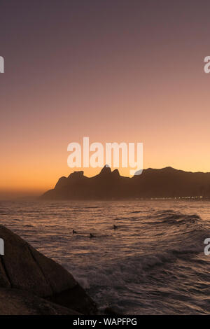 Surfers at Ipanema Beach,Rio de Janeiro from Arpoador during dusk Stock Photo