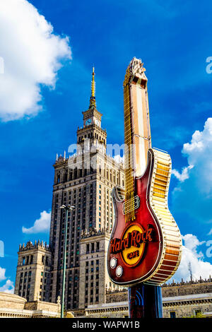 Sign in the shape of a guitar for Hard Rock Cafe with Palace of Culture and Science in the background, Warsaw, Poland Stock Photo