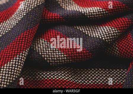 Crumpled red, gray and white striped wool cloth. The volume and texture of the threads can be clearly seen. Stock Photo