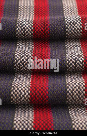 Red, gray and white striped scarf. The wavy volume and texture of the threads can be clearly seen. Stock Photo