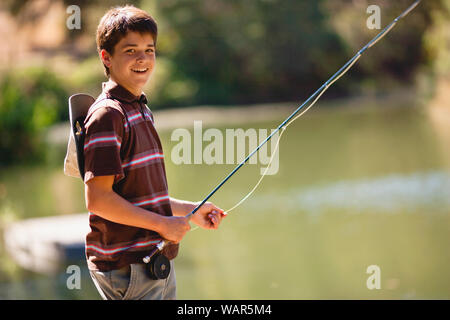 Teenage boy having fun fishing on a lake. Stock Photo