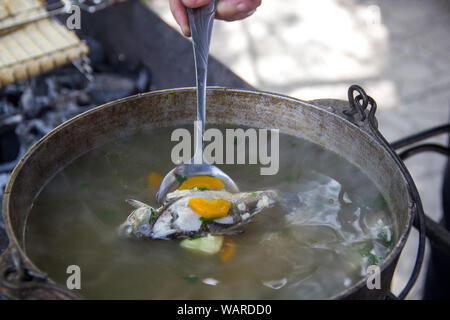 cauldron with an ear at the stake. Fish, potatoes, carrots in a spoon.Ear.Fresh-soup Stock Photo