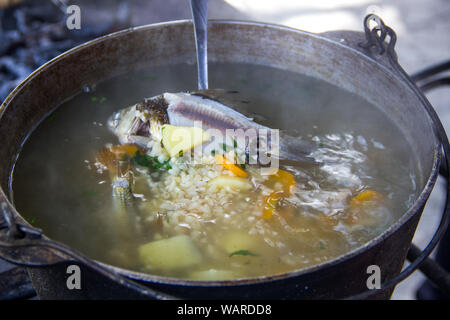 cauldron with an ear at the stake. Fish, potatoes, carrots in a spoon.Ear.Fresh-soup Stock Photo