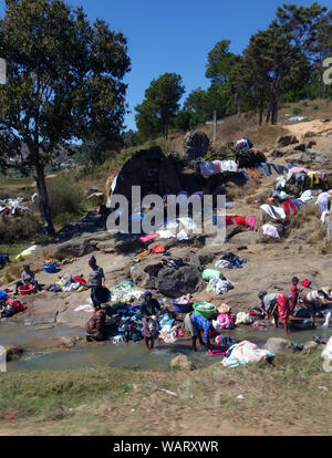 Women washing clothes in stream along highway RN2, outside Antananarivo, Madagascar. No MR or PR Stock Photo