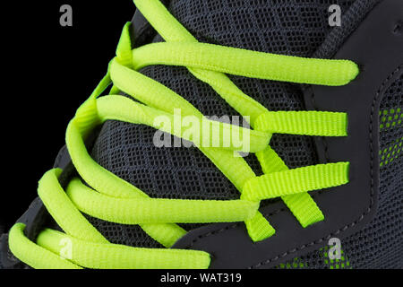 Fragment of black sneaker with green laces close up. Sneaker texture Stock Photo