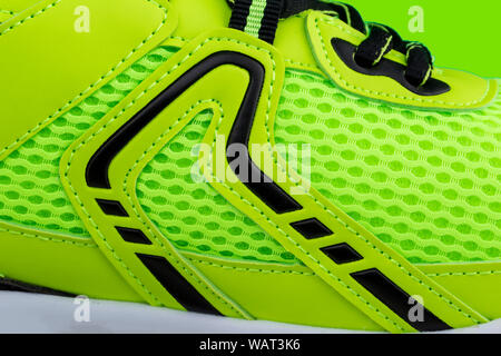 A fragment of a green sneaker with black laces close up. Sneaker texture Stock Photo