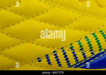 Fragment of a yellow sneaker with blue patch. The texture of the material of sports shoes Stock Photo