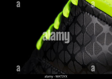 Fragment of black sneaker with green laces close up. Sneaker texture Stock Photo