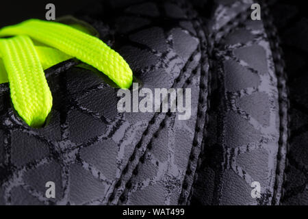 Fragment of black sneaker with green laces close up. Sneaker texture Stock Photo
