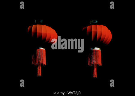 Pair of traditional red silk Chinese hanging lanterns in deep shadow to celebrate Chinese Mid-Autumn Festival and Chinese New Year Stock Photo