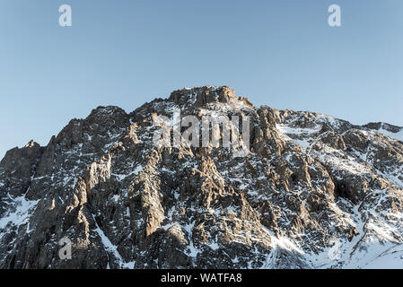 Hiking in Central Asia mountains. background of snowy mountain slope. Winter mountain landscape. toning. Stock Photo
