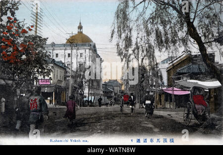 [ 1900s Japan - Bashamichi Road in Yokohama ] —   Bashamichi in Yokohama, Kanagawa Prefecture. The road was built after a large fire had devastated the area in 1866.  Because foreigners passed through in their carriages (basha), the street was called Bashamichi (Carriage Road). The pine and willow trees were the first road side trees planted in Japan.   The large building in the back is the headquarters of the former Yokohama Shokin Bank (Specie Bank), constructed in 1904.  20th century vintage postcard. Stock Photo