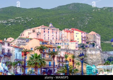 Close-up of colored village in front of greened rocks Stock Photo