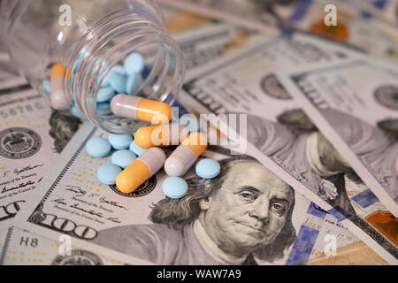 Pills and capsules in a bottle on US dollars bills. Concept of health care, pharmaceutical business, drug prices, pharmacy, medicine and economics Stock Photo