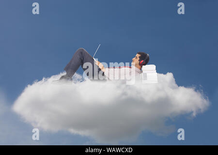 Businessman lying on clouds and using laptop concept cloud computing Stock Photo