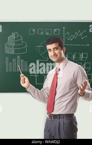 Businessman giving presentation on blackboard Stock Photo