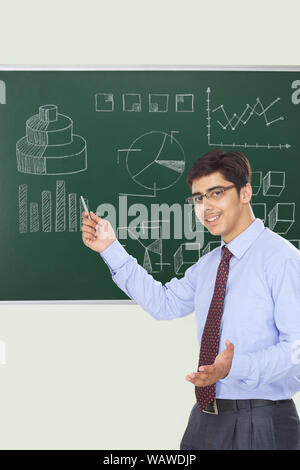 Businessman giving presentation on blackboard Stock Photo