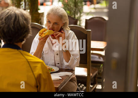 Woman eating a taco in the street cafe. Stock Photo