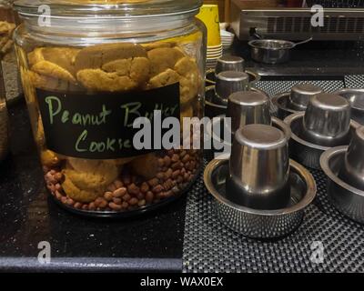 Peanut butter cookie jar with small tin cups on the side. Stock Photo