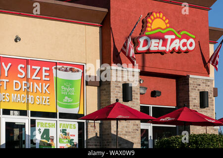 A logo sign outside of a Del Taco fast food restaurant location in