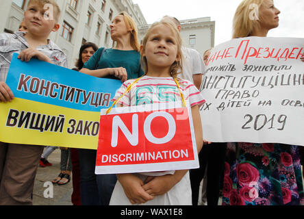 Kiev, Ukraine. 22nd Aug, 2019. Parents with their children hold placards in front of the Presidential Administration during the Rally.Parents, who are against vaccination of their children, demand to stop discrimination of their kids and provide them free access to education, as Ukraine passed the bill, which banned the admission of unvaccinated children to attend educational institutions and left only online and home schooling for them. Credit: SOPA Images Limited/Alamy Live News Stock Photo