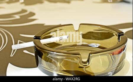 Close up of an cigarette burning in the ashtray. Stock Photo