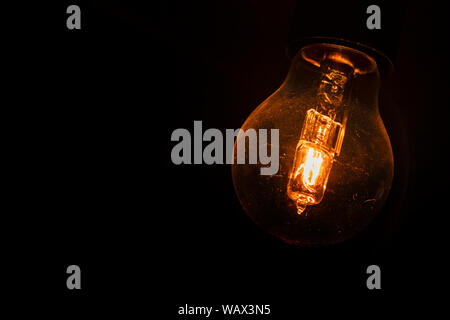 Lightbulb glowing in the dark. Stock Photo