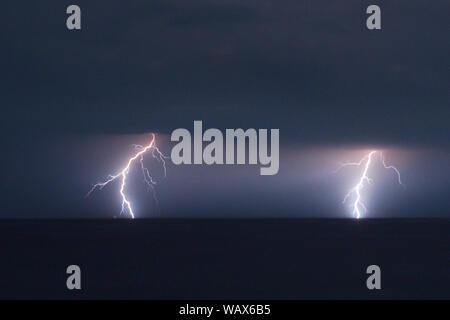 Two branched lightning strikes at night over the Adriatic Sea near the coast of Zadar, Croatia Stock Photo