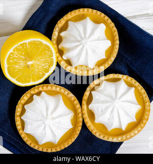 Lemon Meringue Pie. Small Lemon Meringue Pie Dessert Shortcrust Pastry with Lemon Custard Filling and Fluffy Meringue Topping Isolated on a white back Stock Photo