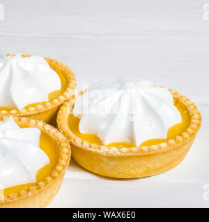 Lemon Meringue Pie. Small Lemon Meringue Pie Dessert Shortcrust Pastry with Lemon Custard Filling and Fluffy Meringue Topping Isolated on a white back Stock Photo